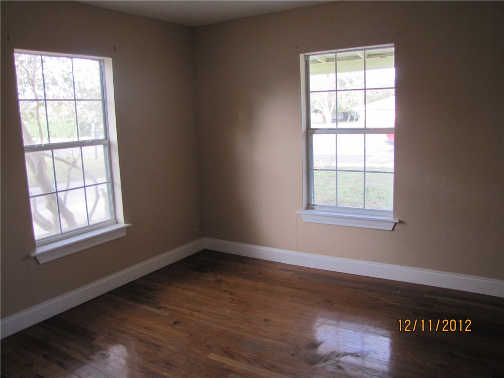 621 Everhart Road Corpus Christi, TX 78412 - Photo 6 of 7 an empty room with wooden floor and windows