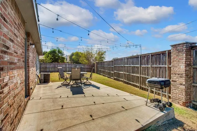 a view of a patio with table and chairs and potted plants