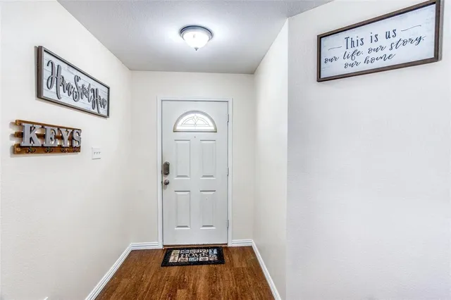 an empty room with wooden floor and mirror