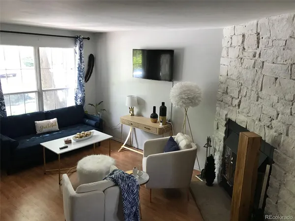 a work room with furniture a flat screen tv and a window