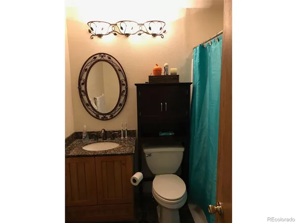 a bathroom with a toilet a sink and a mirror
