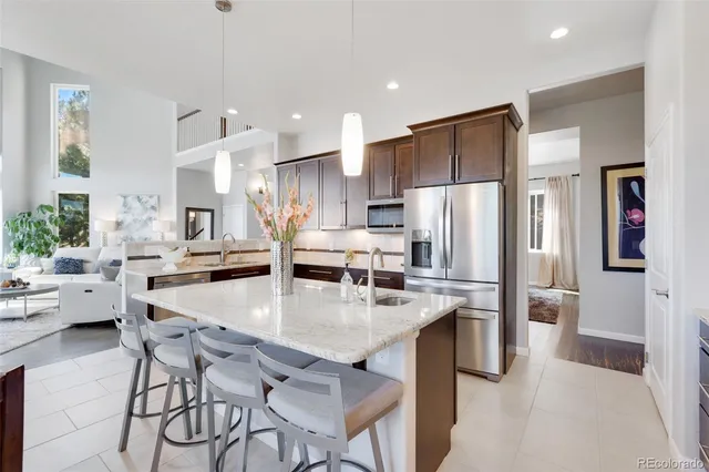 a kitchen with stainless steel appliances kitchen island a refrigerator and a stove top oven