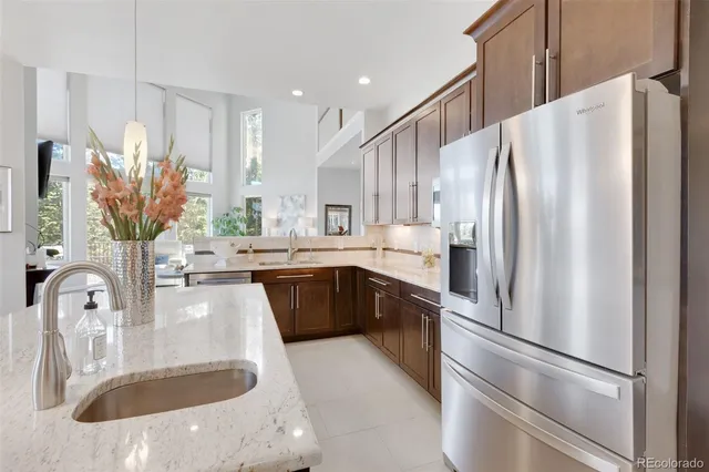 a kitchen with stainless steel appliances granite countertop a refrigerator a sink a stove and a microwave oven