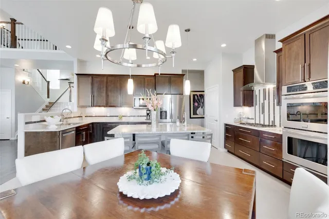 a large kitchen with stainless steel appliances kitchen island granite countertop a large counter top cabinets and couches with wooden floor