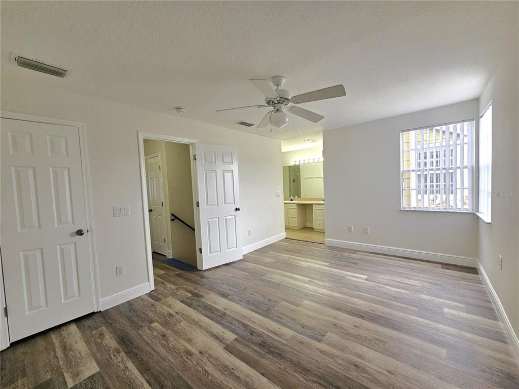 411 Australian Way Davenport, FL 33897 - Photo 14 of 24 a view of an empty room with wooden floor and a window