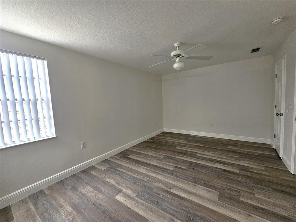 411 Australian Way Davenport, FL 33897 - Photo 18 of 24 wooden floor in an empty room with a window