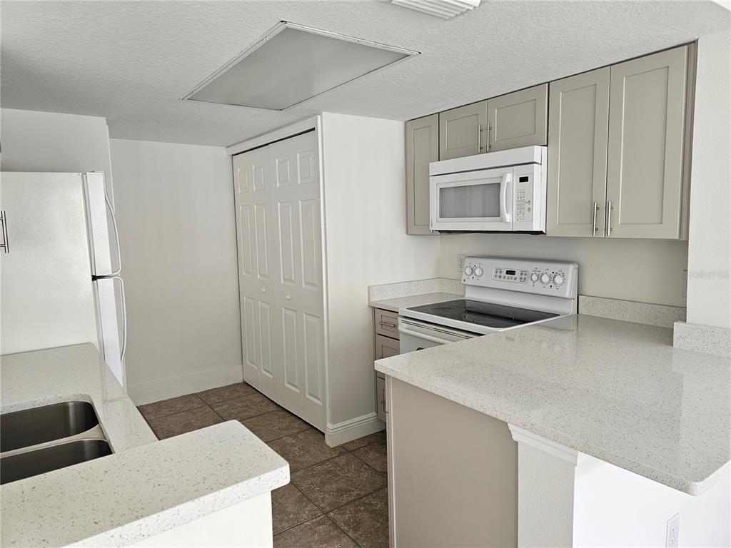 411 Australian Way Davenport, FL 33897 - Photo 4 of 24 a kitchen with stainless steel appliances a refrigerator and a stove top oven