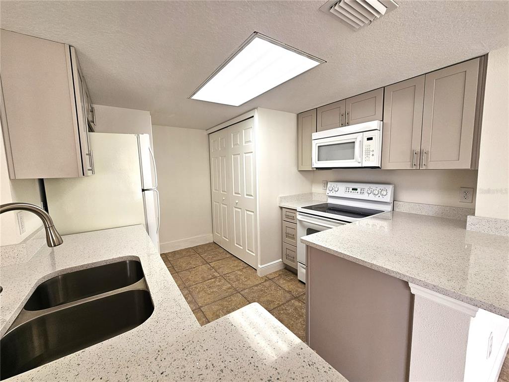 411 Australian Way Davenport, FL 33897 - Photo 6 of 24 a kitchen with a sink a stove and a refrigerator