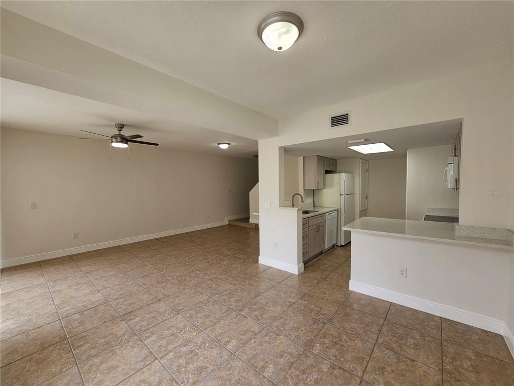 411 Australian Way Davenport, FL 33897 - Photo 10 of 24 a view of a kitchen with a sink hardwood floor and a living room