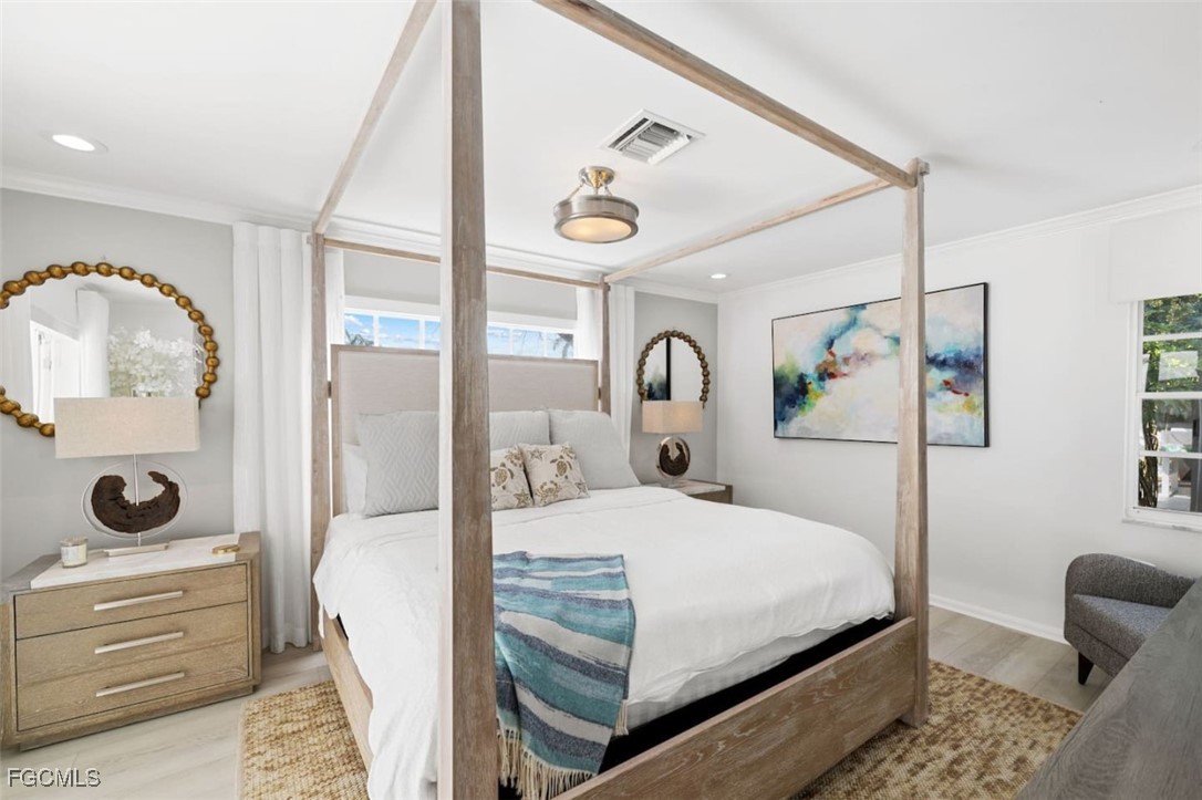 2728 Crayton Road Naples, FL 34103 - Photo 19 of 35 a bedroom with a bed and wooden floor