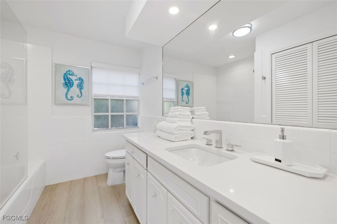 2728 Crayton Road Naples, FL 34103 - Photo 30 of 35 a bathroom with a sink a toilet and a bathtub