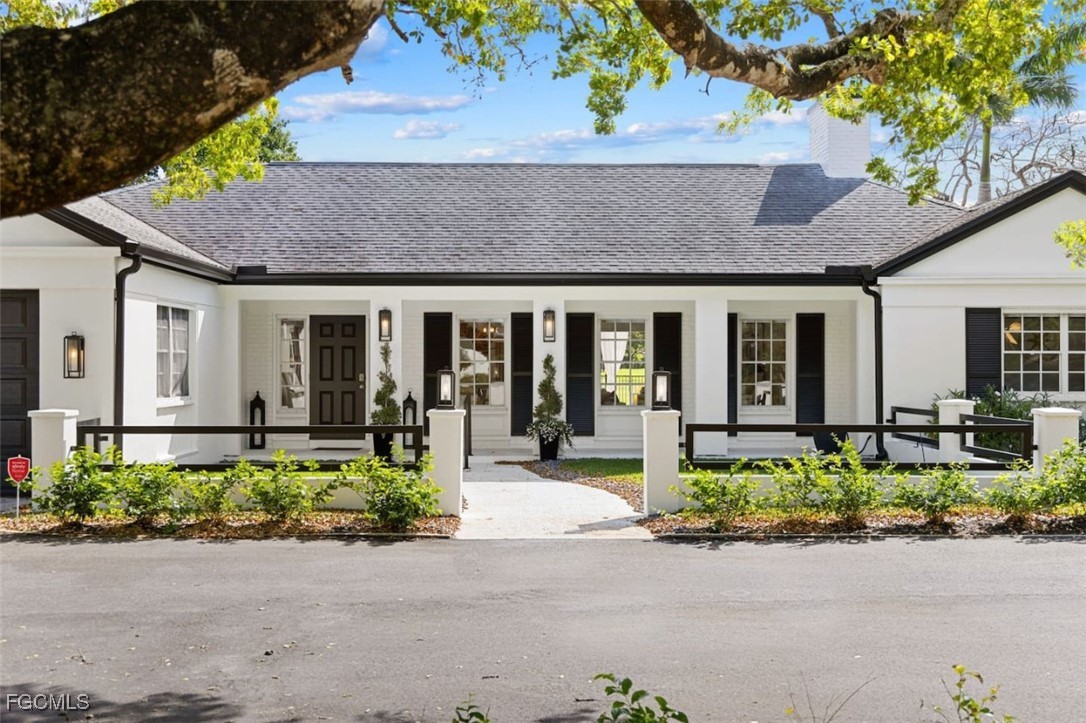 2728 Crayton Road Naples, FL 34103 - Photo 33 of 35 front view of house with a small yard