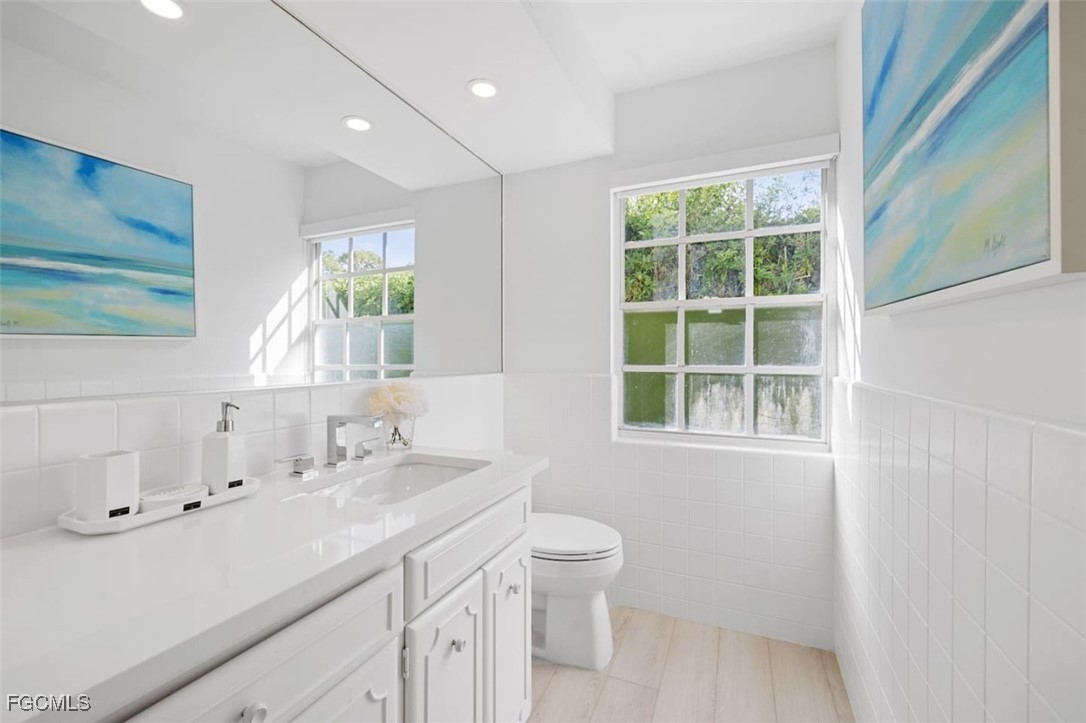 2728 Crayton Road Naples, FL 34103 - Photo 34 of 35 a bathroom with a sink a toilet and a window