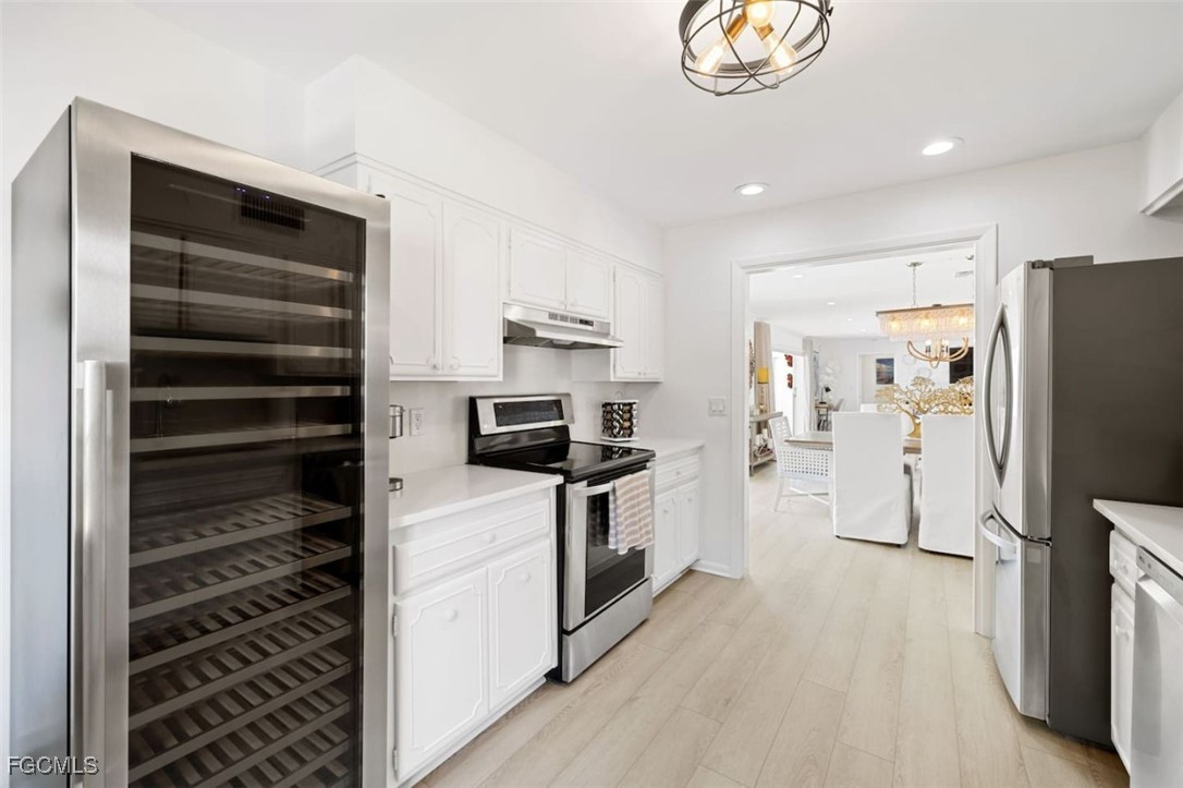 2728 Crayton Road Naples, FL 34103 - Photo 10 of 35 a kitchen with a refrigerator and a sink