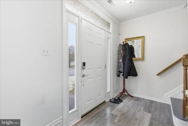 a view of a hallway with wooden floor and entryway