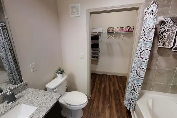 a bedroom with a bed and a lamp on dresser