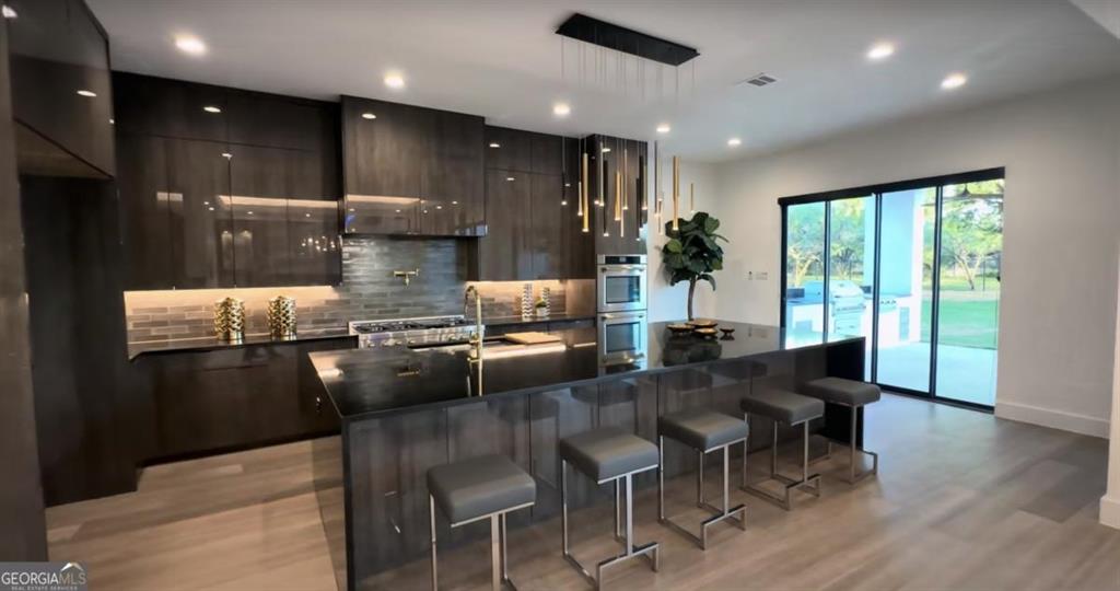 6711 Bishop Road Fairburn, GA 30213 - Photo 5 of 7 a kitchen with stainless steel appliances granite countertop table chairs and wooden floor