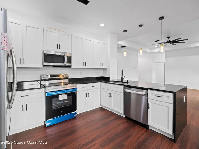 a kitchen with white cabinets and stainless steel appliances