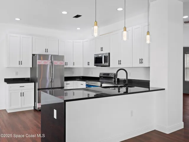 a kitchen with kitchen island stainless steel appliances a sink and cabinets