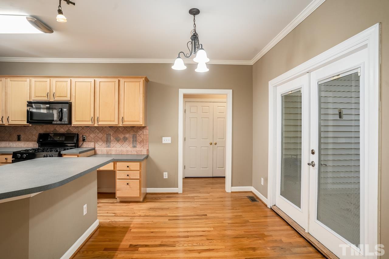 6336 Nowell Pointe Drive Raleigh, NC 27607 - Photo 8 of 25 a kitchen with granite countertop a stove top oven a sink and a refrigerator