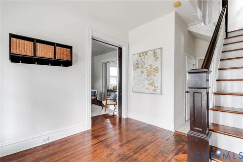 a view of a hallway with wooden floor and staircase
