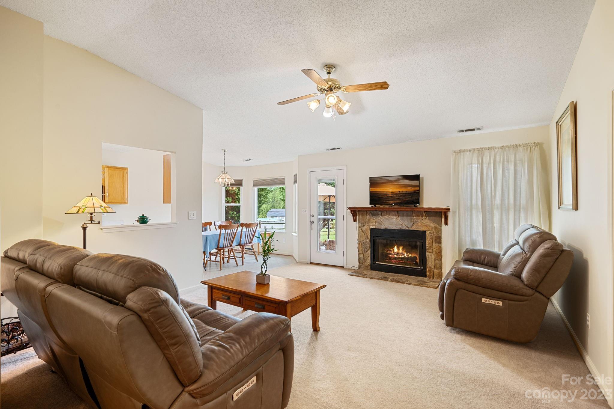 3691 Slanting Bridge Road Sherrills Ford, NC 28673 - Photo 5 of 33 a living room with furniture a fireplace and a flat screen tv