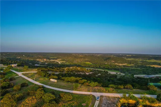 an aerial view of ocean and residential houses with outdoor space