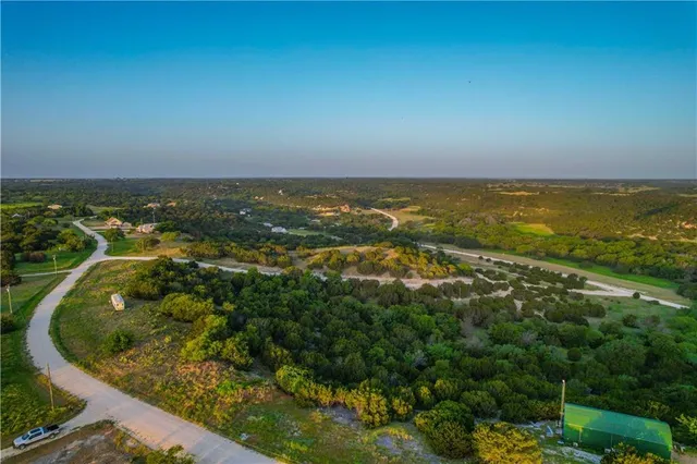 an aerial view of residential houses with outdoor space and trees