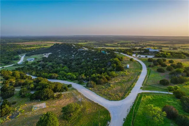 an aerial view of residential houses with outdoor space and trees