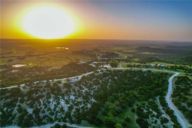 an aerial view of residential houses with outdoor space and trees