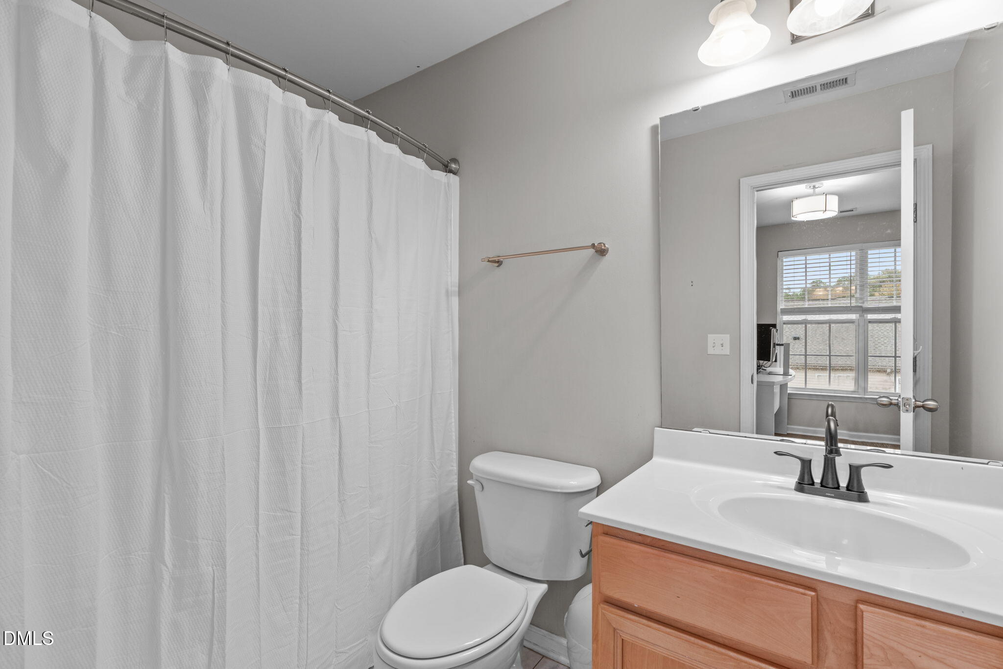 9909 Grettle Court Raleigh, NC 27617 - Photo 18 of 23 a bathroom with a sink a toilet and shower curtain