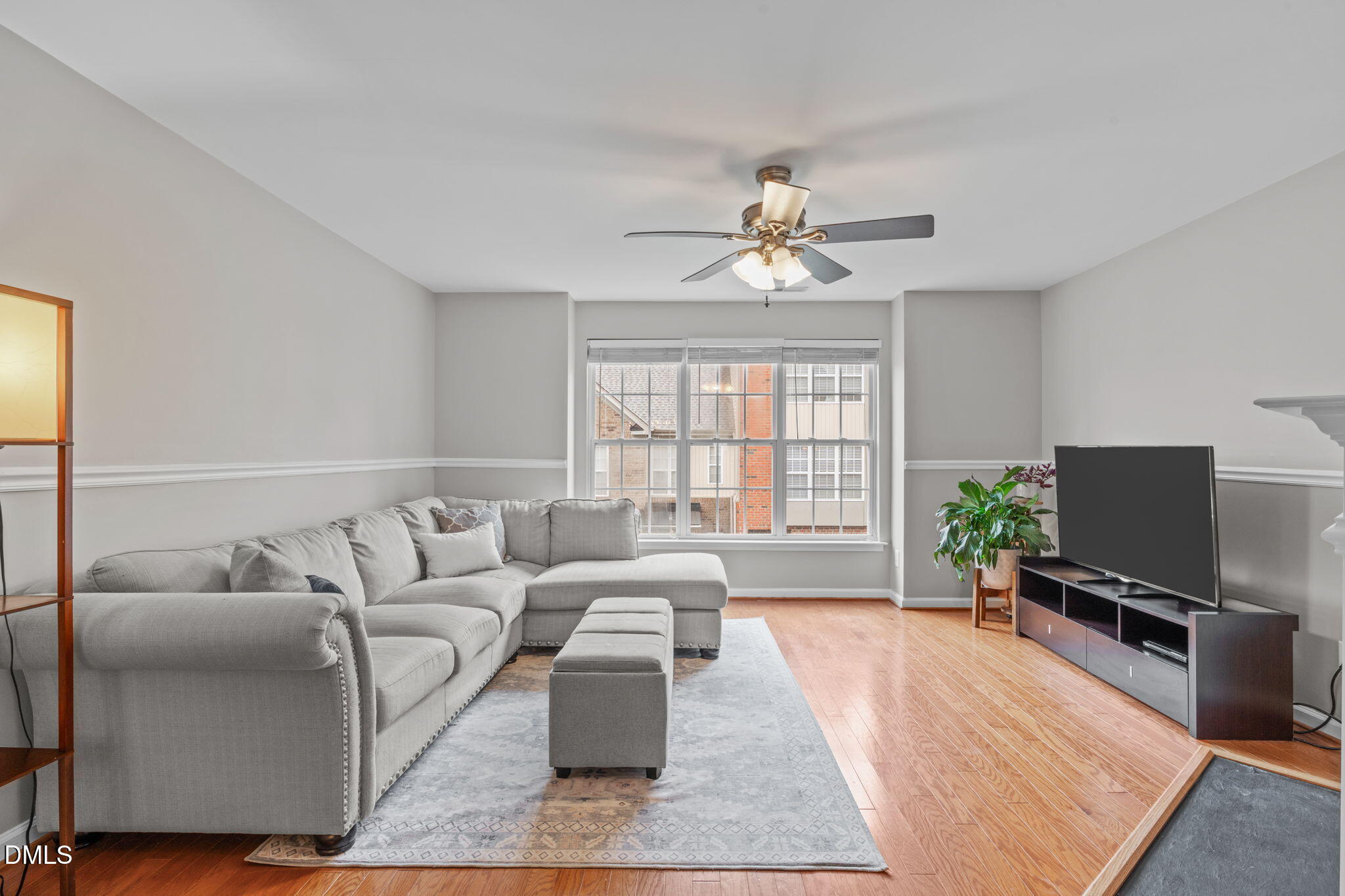 9909 Grettle Court Raleigh, NC 27617 - Photo 2 of 23 a living room with furniture a flat screen tv and a large window