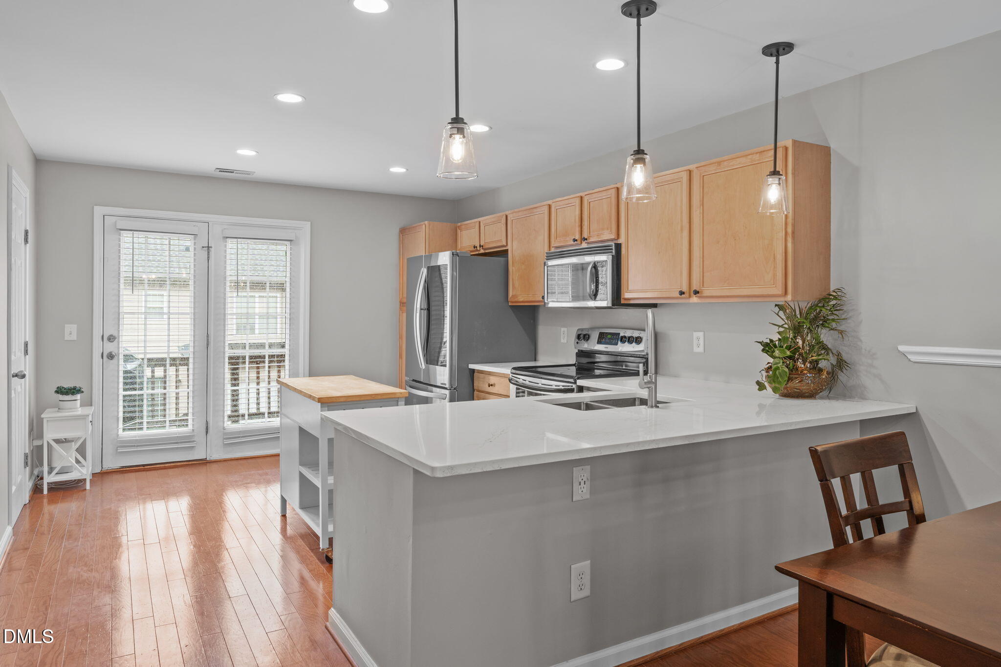 9909 Grettle Court Raleigh, NC 27617 - Photo 3 of 23 a kitchen with sink refrigerator and microwave