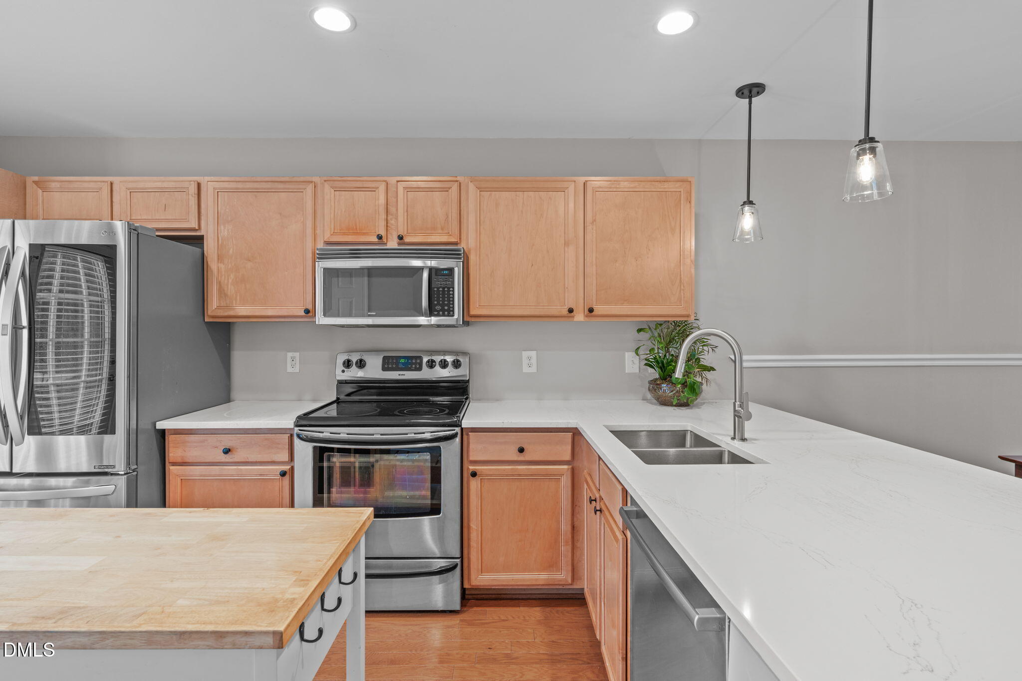 9909 Grettle Court Raleigh, NC 27617 - Photo 8 of 23 a kitchen with a sink a stove and a microwave