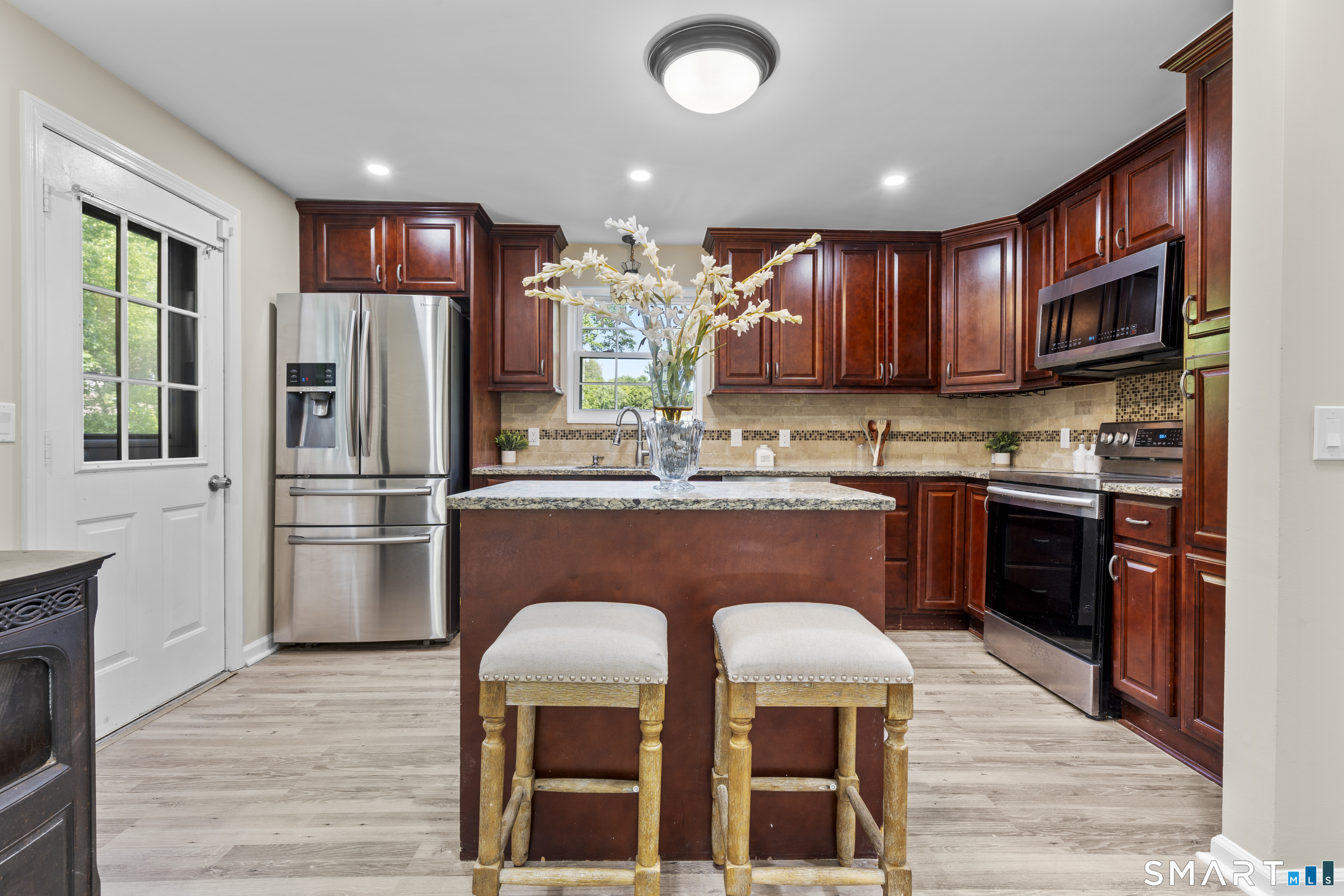 13 Williams Court Wolcott, CT 06716 - Photo 6 of 33 a kitchen with stainless steel appliances granite countertop a refrigerator a stove top oven a sink and dishwasher with wooden floor
