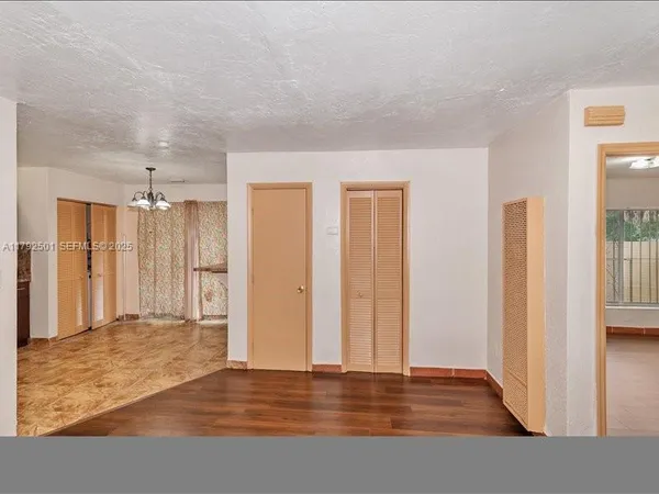 a view of an empty room with wooden floor