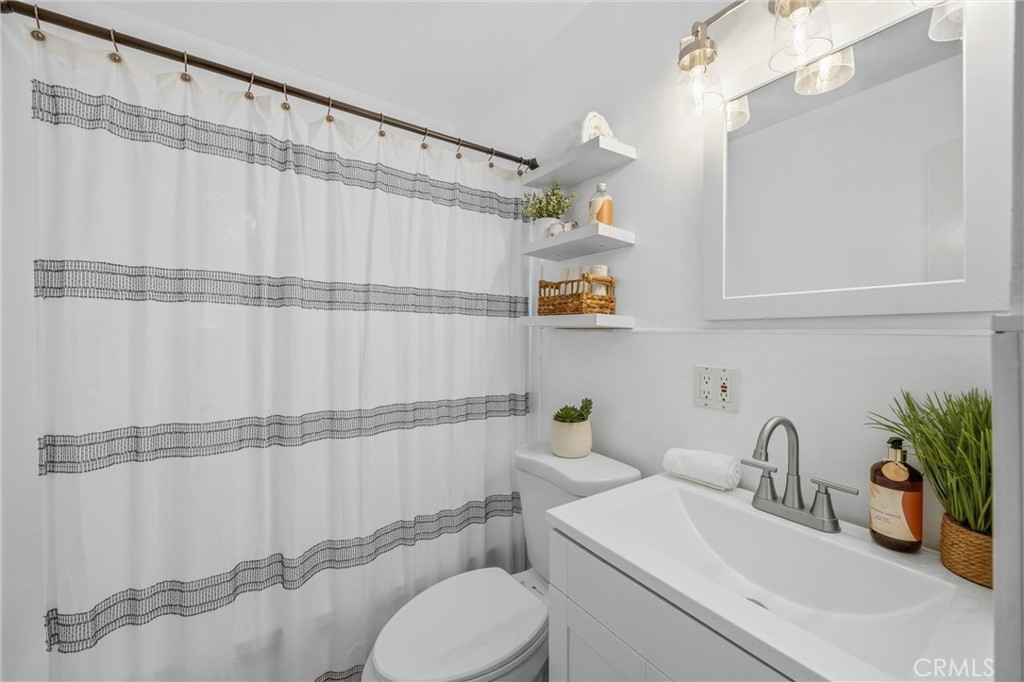 186 North Center Place Redlands, CA 92373 - Photo 23 of 28 a bathroom with a sink a toilet and shower curtain