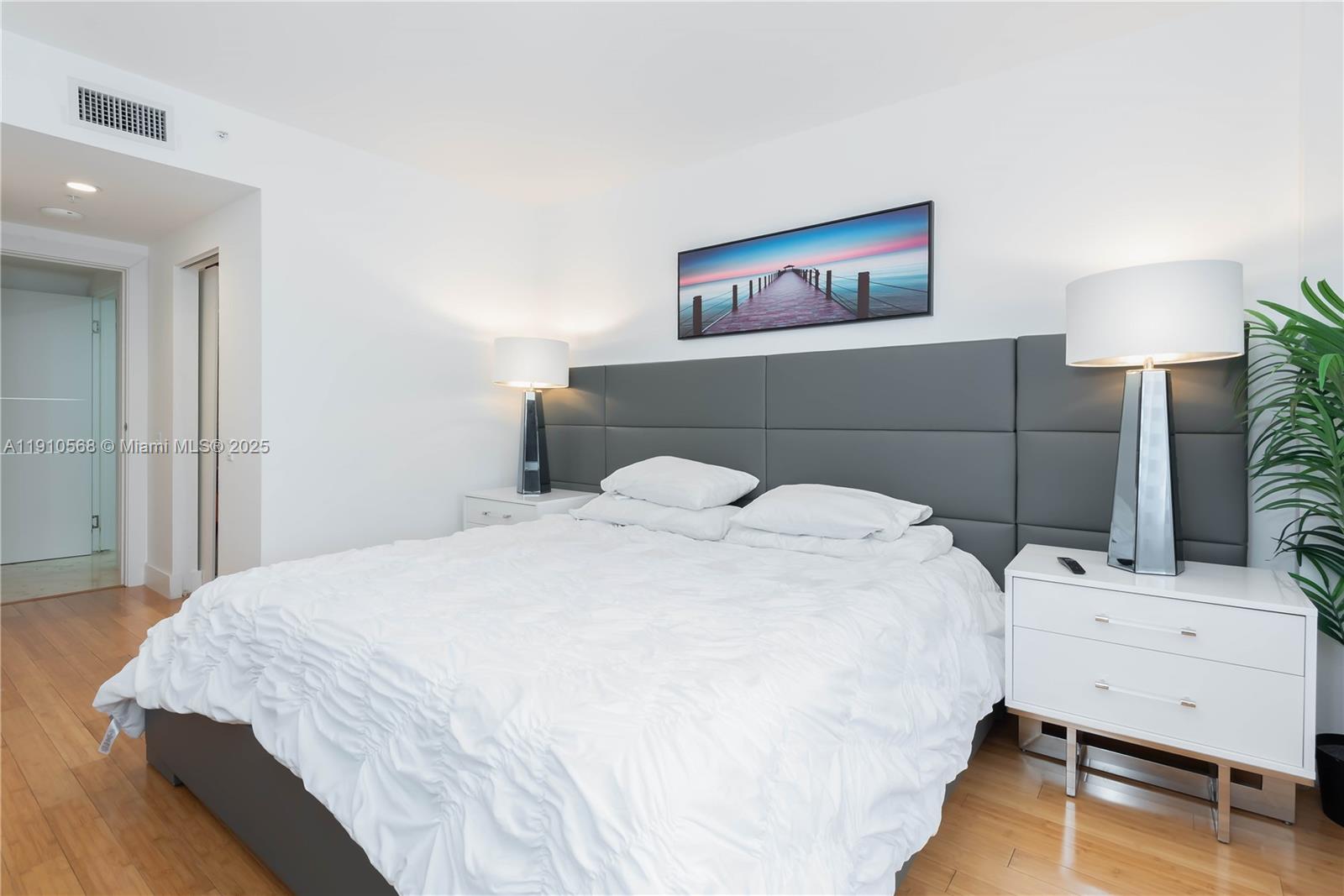 701 Brickell Key Boulevard, Unit 1912 Miami, FL 33131 - Photo 16 of 67 a bedroom with a bed and a lamp on table