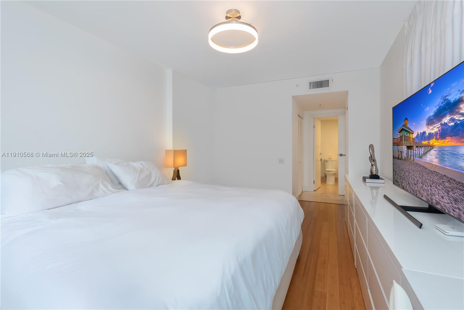 701 Brickell Key Boulevard, Unit 1912 Miami, FL 33131 - Photo 22 of 67 a bedroom with a bed and wooden floor