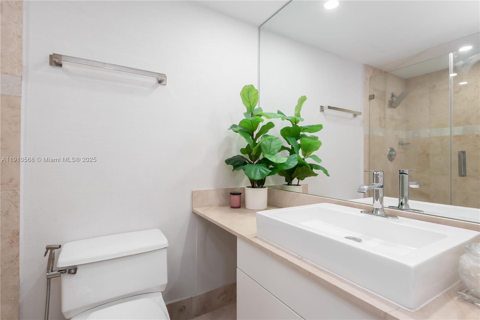 701 Brickell Key Boulevard, Unit 1912 Miami, FL 33131 - Photo 28 of 67 a bathroom with a sink a toilet and a mirror