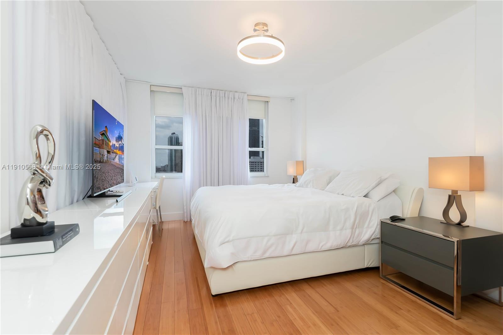 701 Brickell Key Boulevard, Unit 1912 Miami, FL 33131 - Photo 31 of 67 a spacious bedroom with a bed and a flat tv screen on the dresser