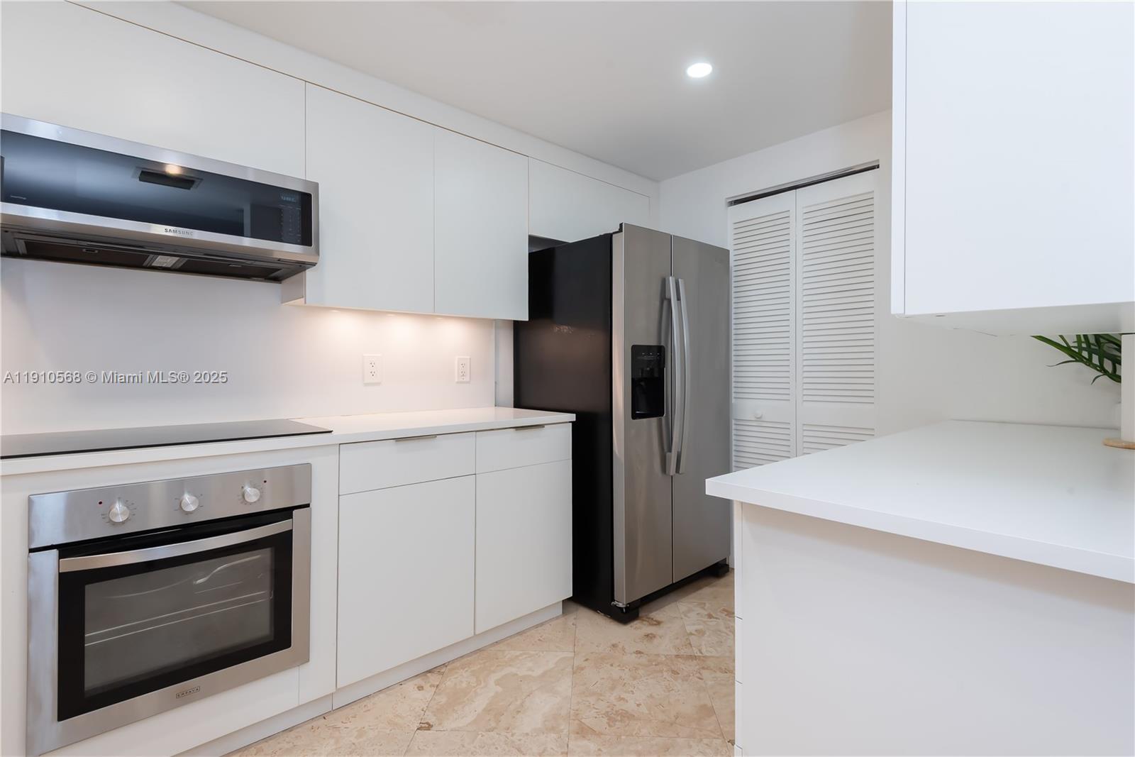 701 Brickell Key Boulevard, Unit 1912 Miami, FL 33131 - Photo 35 of 67 a kitchen with stainless steel appliances white cabinets and a refrigerator