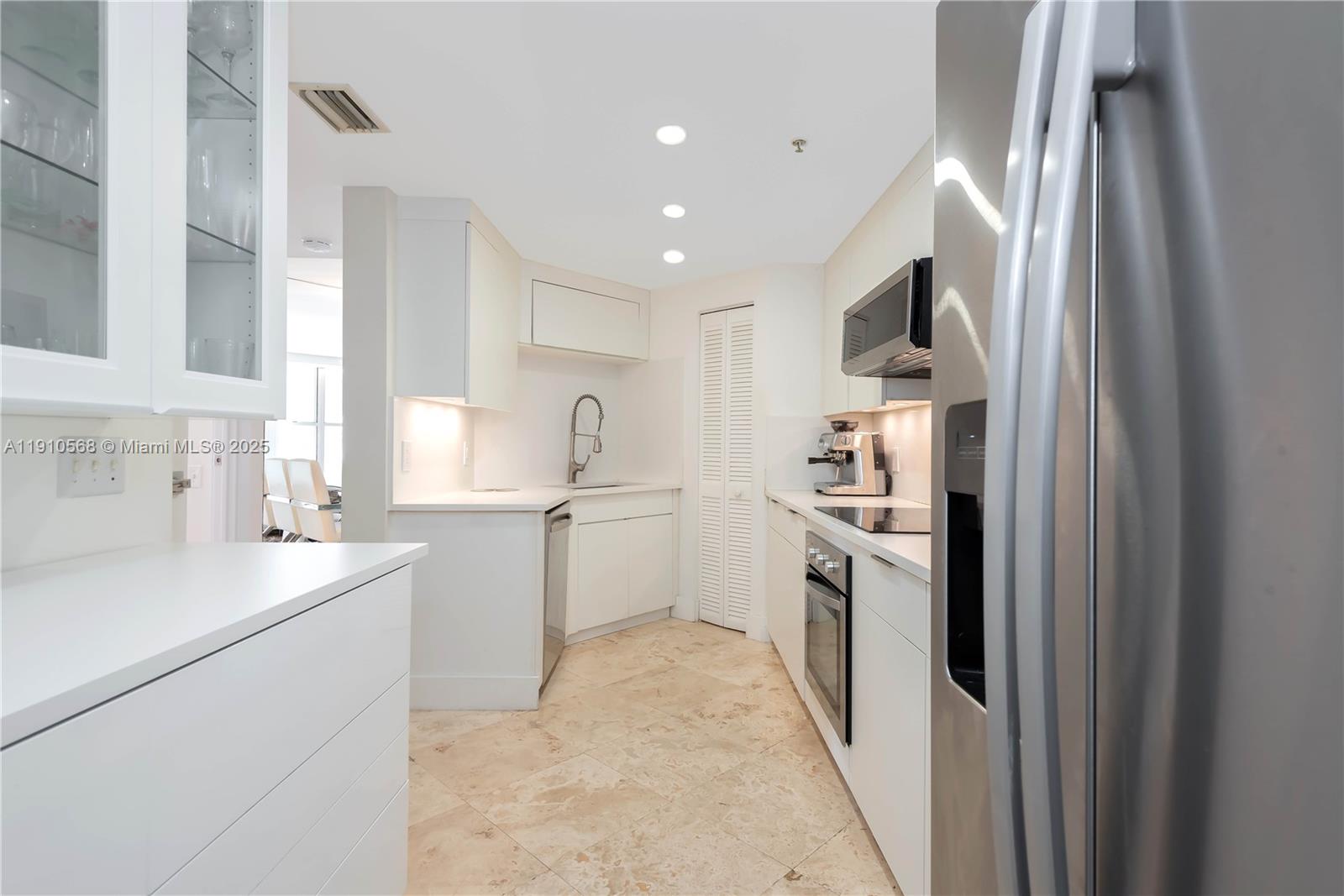 701 Brickell Key Boulevard, Unit 1912 Miami, FL 33131 - Photo 37 of 67 a kitchen with white cabinets and white appliances