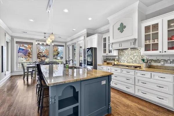 a kitchen with stainless steel appliances granite countertop a kitchen island and a stove in it