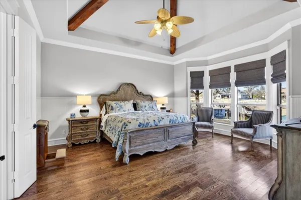 a bedroom with a bed ceiling fan and a large window