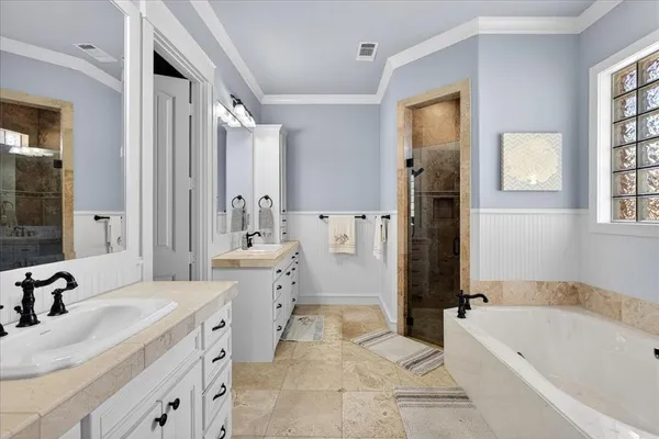 a spacious bathroom with a tub sink and mirror