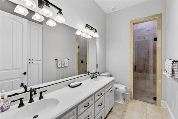 a bathroom with double vanity and a mirror