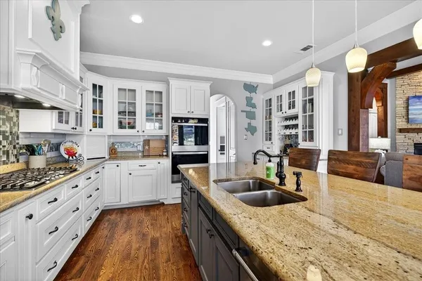 a kitchen with stainless steel appliances granite countertop a sink dishwasher stove and refrigerator