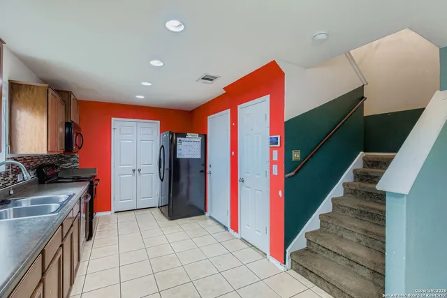 a kitchen with stainless steel appliances granite countertop a refrigerator and a sink