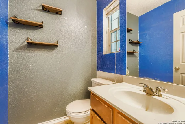 a bathroom with a sink a toilet and a mirror